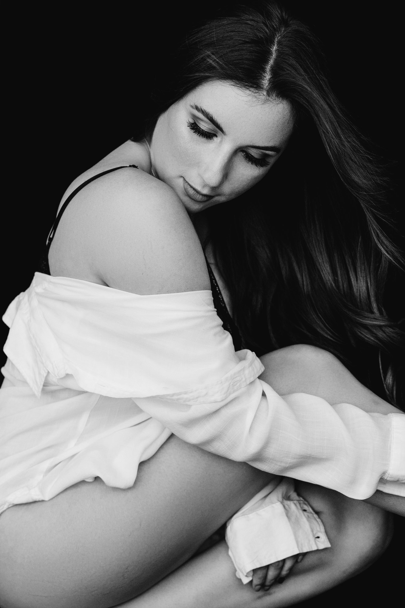 Intimate monochrome portrait beneath a loose white shirt