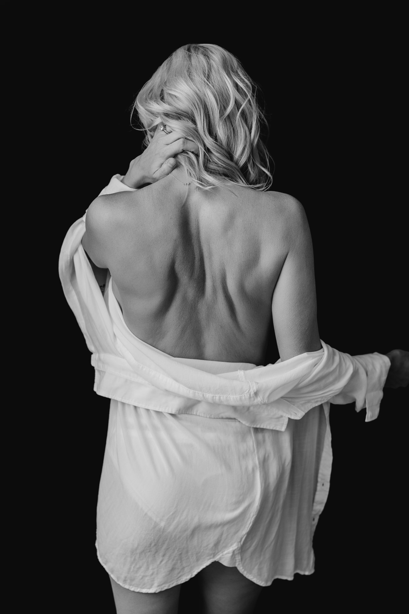 Bare-back boudoir portrait with a draped white shirt