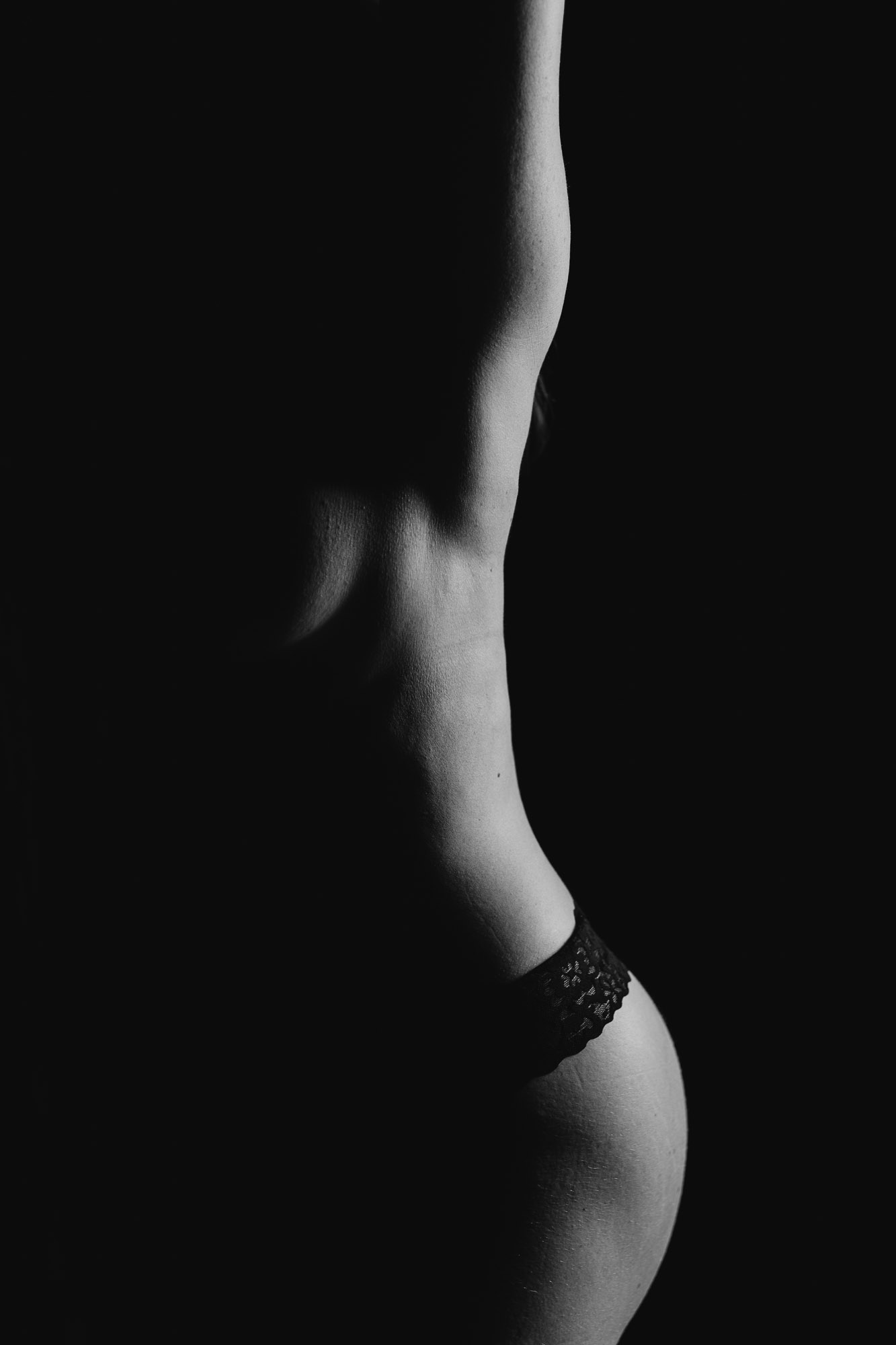 Dramatic low-key fine-art boudoir contour study