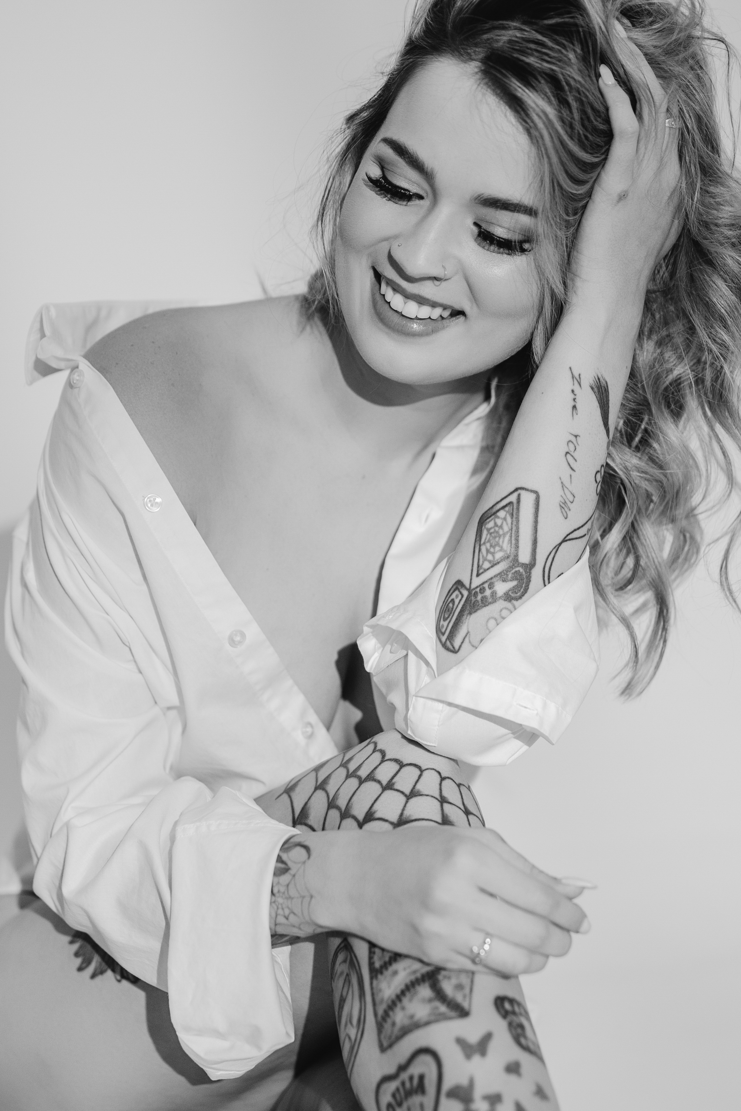 Smiling woman in a white shirt in a black-and-white Las Vegas boudoir portrait