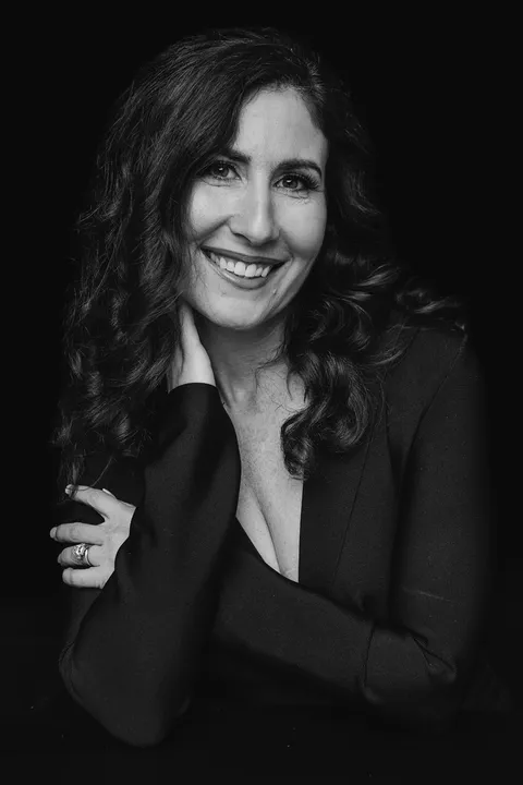 Black-and-white editorial Boise headshot — woman in plunge blazer, dark backdrop, J Renee Studios